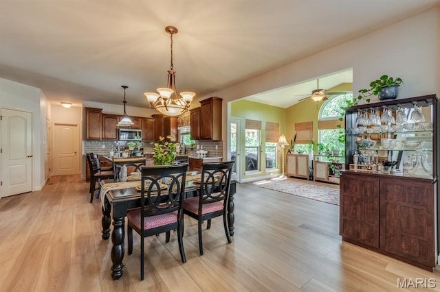 3026 Windsor Point Dr, Saint Louis, MO 63129 - dining room featuring a chandelier, light wood-style flooring, vaulted ceiling, and a ceiling fan