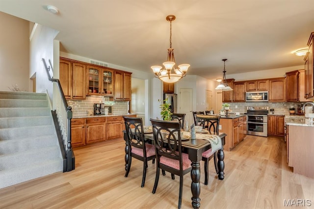 3026 Windsor Point Dr, Saint Louis, MO 63129 - dining room featuring light wood finished floors, a chandelier, and stairway