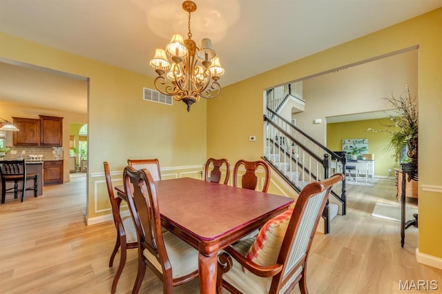 3026 Windsor Point Dr, Saint Louis, MO 63129 - dining area featuring a chandelier, light wood-style floors, and stairs