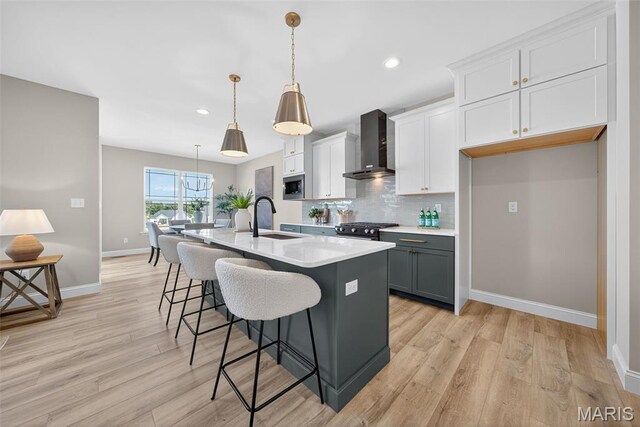 554 Wheatfield Cir, Ofallon, MO 63385 - kitchen featuring wall chimney exhaust hood, appliances with stainless steel finishes, a center island with sink, a kitchen breakfast bar, and backsplash