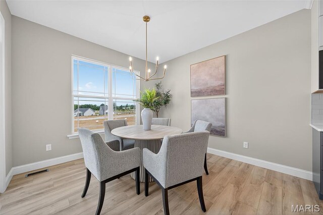554 Wheatfield Cir, Ofallon, MO 63385 - dining room with light wood-style flooring and a chandelier