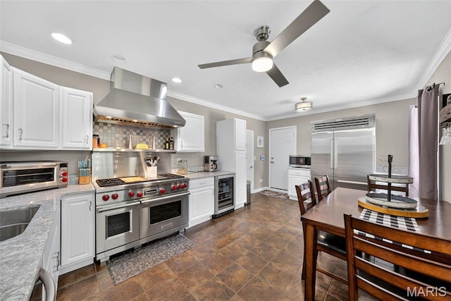 11365 Inverness Ln, Maryland Heights, MO 63043 - kitchen featuring high quality appliances, wall chimney range hood, beverage cooler, a ceiling fan, and ornamental molding
