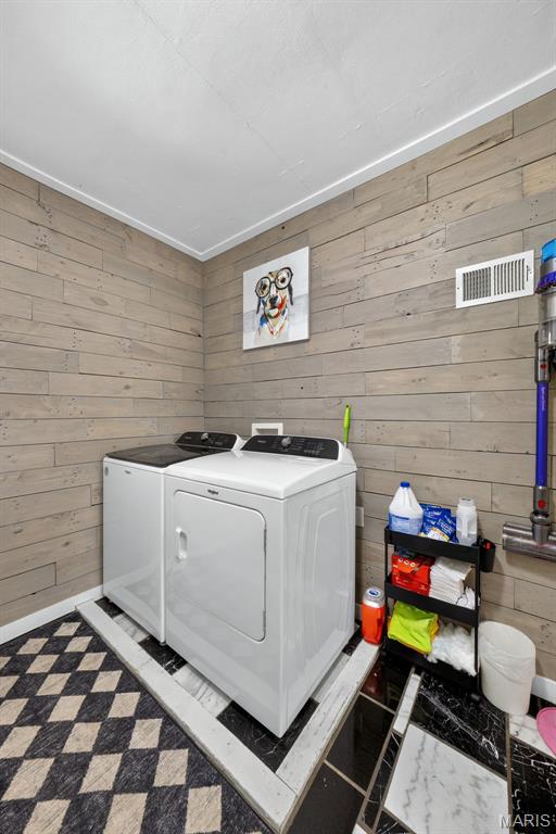 11365 Inverness Ln, Maryland Heights, MO 63043 - laundry room with washing machine and dryer and wooden walls
