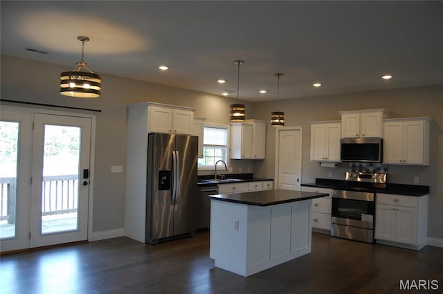 1002 E Donna Dr, Poplar Bluff, MO 63901 - kitchen with stainless steel appliances, dark countertops, white cabinets, a center island, and dark wood-style flooring