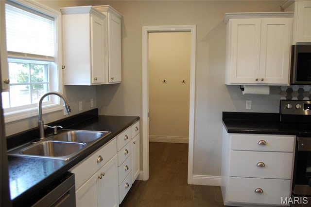 1002 E Donna Dr, Poplar Bluff, MO 63901 - kitchen featuring stainless steel appliances, dark countertops, white cabinetry, and dark wood-style flooring