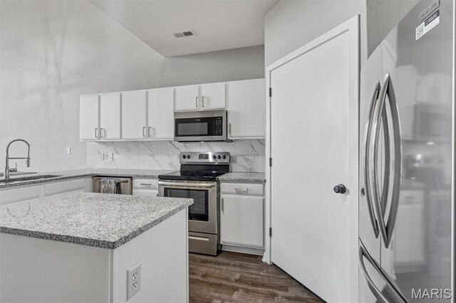200 S Kirkwood Rd Unit 317, Kirkwood, MO 63122 - kitchen featuring appliances with stainless steel finishes, white cabinetry, backsplash, dark wood-style floors, and light stone counters