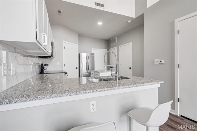200 S Kirkwood Rd Unit 317, Kirkwood, MO 63122 - kitchen with freestanding refrigerator, range, white cabinetry, light stone countertops, and a peninsula