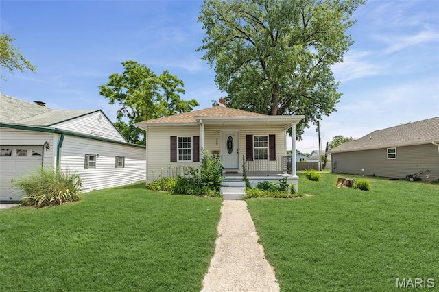 208 Washington Ave, East Alton, IL 62024 - view of front facade with covered porch, a front yard, and an attached garage
