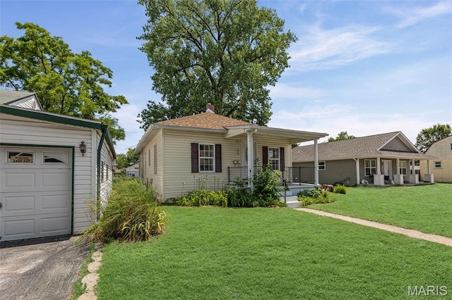 208 Washington Ave, East Alton, IL 62024 - view of front of property with covered porch, a front lawn, a chimney, a garage, and asphalt driveway
