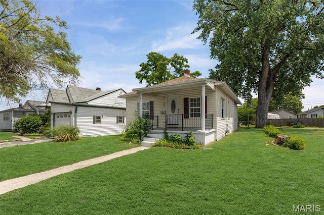 208 Washington Ave, East Alton, IL 62024 - view of front facade with a porch, a garage, and a chimney