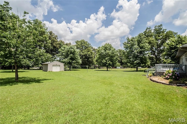5707 Cedar Rdg, Poplar Bluff, MO 63901 - view of green lawn featuring a deck, a detached garage, a shed, and view of wooded area
