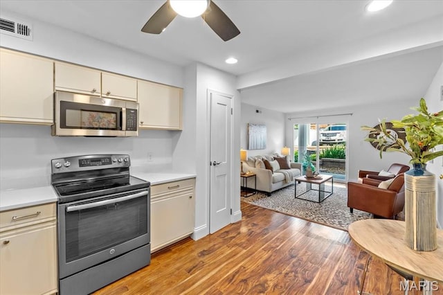 149 Jubilee Hill Dr Unit A, Wildwood, MO 63040 - kitchen with appliances with stainless steel finishes, cream cabinets, light countertops, a ceiling fan, and light wood finished floors