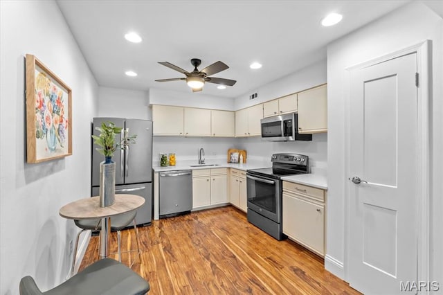 149 Jubilee Hill Dr Unit A, Wildwood, MO 63040 - kitchen with stainless steel appliances, light countertops, light wood-style floors, ceiling fan, and cream cabinets