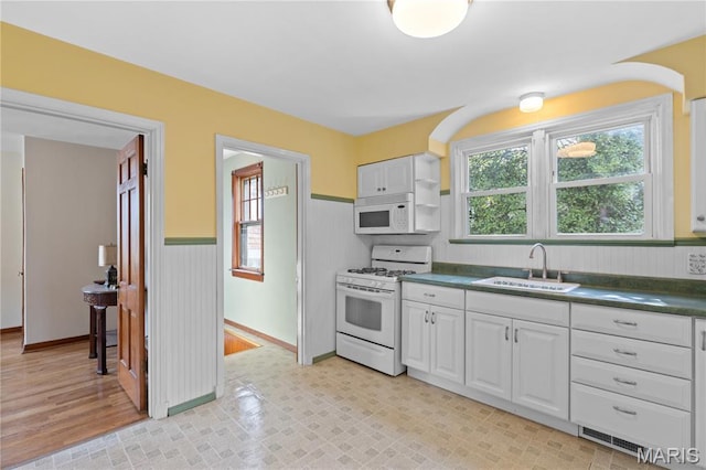 6312 Bradley Ave, Saint Louis, MO 63139 - kitchen with white appliances, dark countertops, white cabinets, and wainscoting