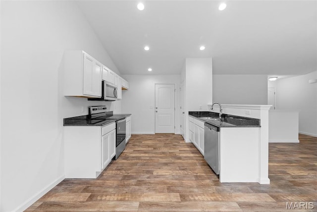 906 Gimli Ln, Wright City, MO 63390 - kitchen with appliances with stainless steel finishes, a peninsula, recessed lighting, white cabinets, and wood finished floors
