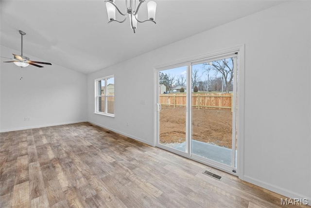 906 Gimli Ln, Wright City, MO 63390 - empty room with vaulted ceiling, healthy amount of natural light, wood finished floors, a chandelier, and a ceiling fan