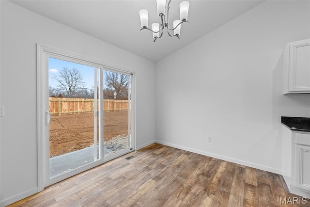 906 Gimli Ln, Wright City, MO 63390 - unfurnished dining area with light wood-type flooring, a chandelier, and lofted ceiling