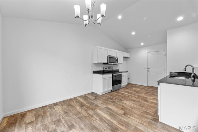 906 Gimli Ln, Wright City, MO 63390 - kitchen with appliances with stainless steel finishes, wood finished floors, white cabinetry, recessed lighting, and dark stone countertops