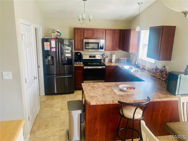 145 Champions Ln, Wentzville, MO 63385 - kitchen with stainless steel appliances, vaulted ceiling, a peninsula, hanging light fixtures, and light countertops