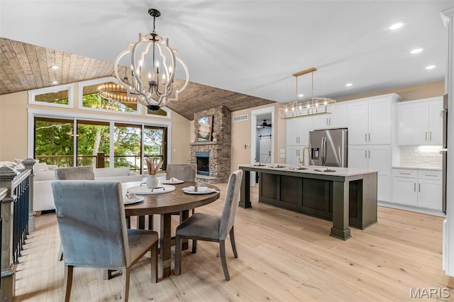 10028 Debbie Pl, Bonne Terre, MO 63628 - dining area featuring a chandelier, a fireplace, light wood-style flooring, recessed lighting, and high vaulted ceiling