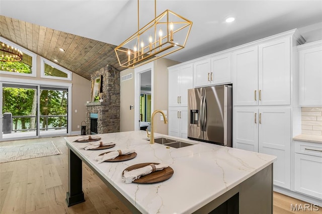 10028 Debbie Pl, Bonne Terre, MO 63628 - kitchen with stainless steel refrigerator with ice dispenser, white cabinetry, light wood-style flooring, light stone countertops, and high vaulted ceiling