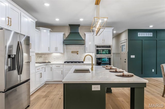 10028 Debbie Pl, Bonne Terre, MO 63628 - kitchen with stainless steel appliances, custom exhaust hood, white cabinetry, tasteful backsplash, and recessed lighting