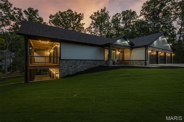 10028 Debbie Pl, Bonne Terre, MO 63628 - back of property at dusk featuring stone siding, a garage, a yard, and driveway