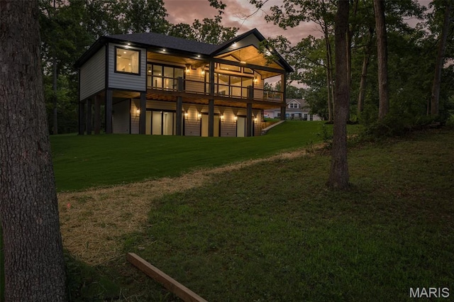 10028 Debbie Pl, Bonne Terre, MO 63628 - back of property at dusk with a lawn and a wooden deck