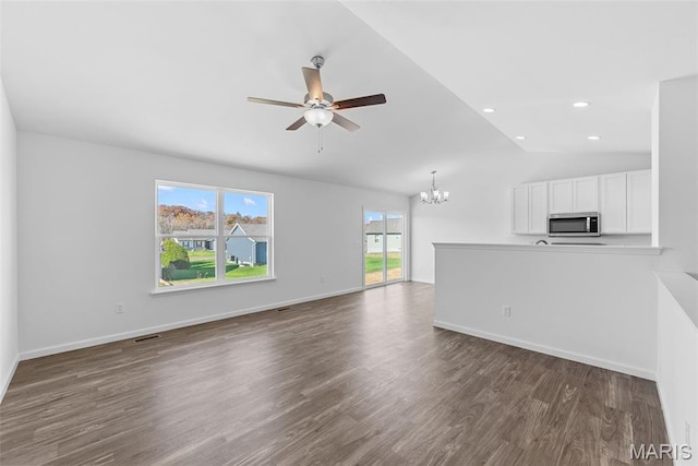 912 Gimli Ln, Wright City, MO 63390 - unfurnished living room with a ceiling fan, a chandelier, healthy amount of natural light, dark wood-type flooring, and vaulted ceiling