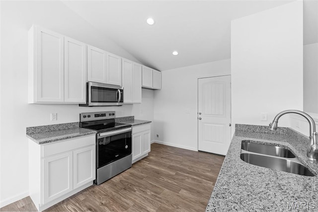 912 Gimli Ln, Wright City, MO 63390 - kitchen featuring stainless steel appliances, light stone counters, lofted ceiling, wood finished floors, and white cabinetry