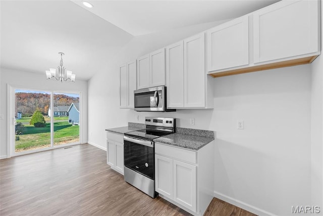 912 Gimli Ln, Wright City, MO 63390 - kitchen featuring appliances with stainless steel finishes, a chandelier, light wood-style flooring, lofted ceiling, and white cabinets