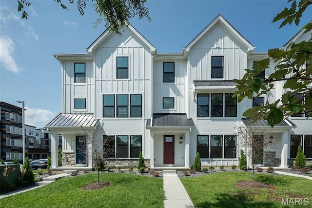 8912 Gateway Cir, Richmond Heights, MO 63144 - view of front of house with a standing seam roof, a front lawn, stone siding, and a metal roof