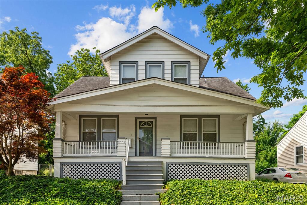 7052 Tholozan Ave, Saint Louis, MO 63109 - bungalow with covered porch, a shingled roof, and stairs