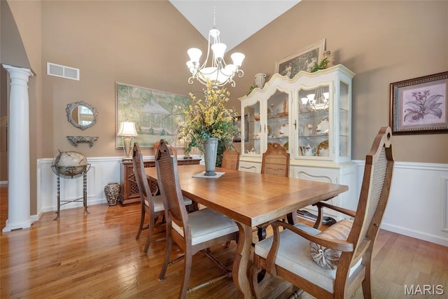 112 Wake Forest Pl, Ofallon, MO 63368 - dining area featuring decorative columns, high vaulted ceiling, a wainscoted wall, a chandelier, and light wood-style floors