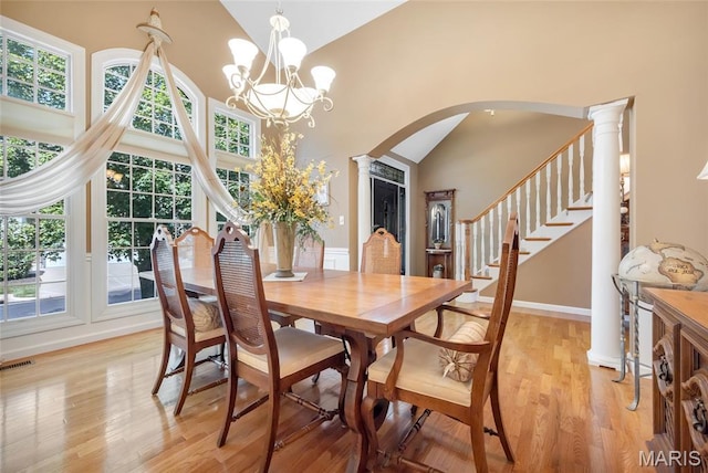 112 Wake Forest Pl, Ofallon, MO 63368 - dining room with arched walkways, plenty of natural light, high vaulted ceiling, light wood finished floors, and a chandelier