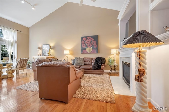 112 Wake Forest Pl, Ofallon, MO 63368 - living area featuring high vaulted ceiling, a fireplace, light wood finished floors, and rail lighting