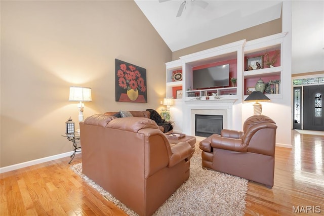 112 Wake Forest Pl, Ofallon, MO 63368 - living area featuring light wood-style floors, a ceiling fan, a glass covered fireplace, and high vaulted ceiling