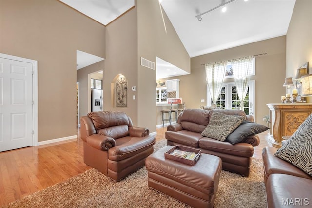 112 Wake Forest Pl, Ofallon, MO 63368 - living room with rail lighting, high vaulted ceiling, and light wood-style floors