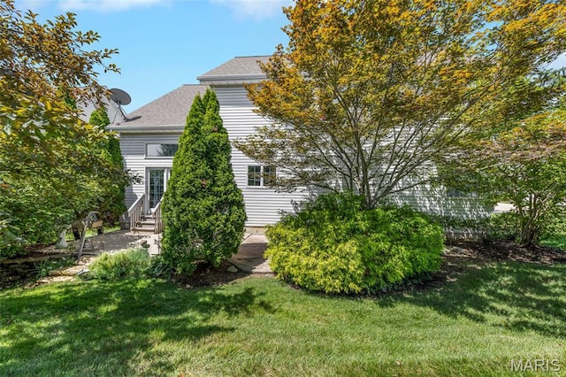 112 Wake Forest Pl, Ofallon, MO 63368 - view of side of home with entry steps, a lawn, a shingled roof, and a patio