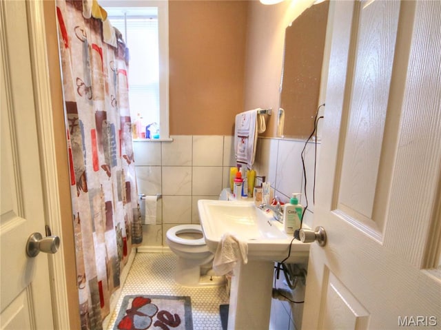 5912 Arsenal St, Saint Louis, MO 63139 - bathroom featuring tile patterned flooring, tile walls, a wainscoted wall, and a shower with curtain