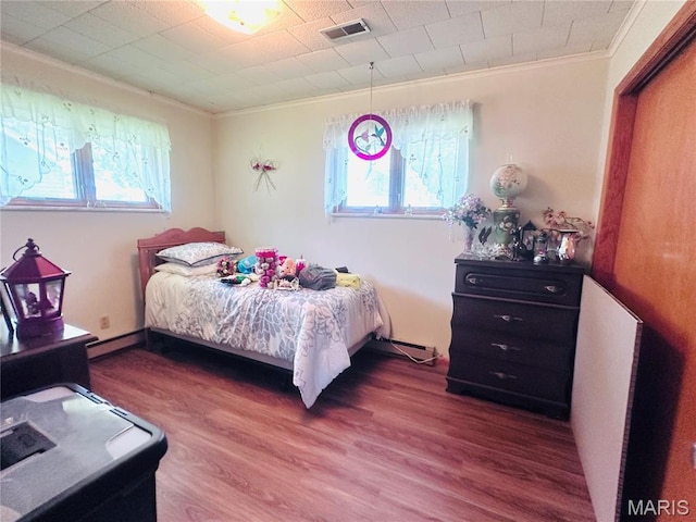 1620 N Jefferson St, Mexico, MO 65265 - bedroom featuring ornamental molding, multiple windows, wood finished floors, and a baseboard heating unit