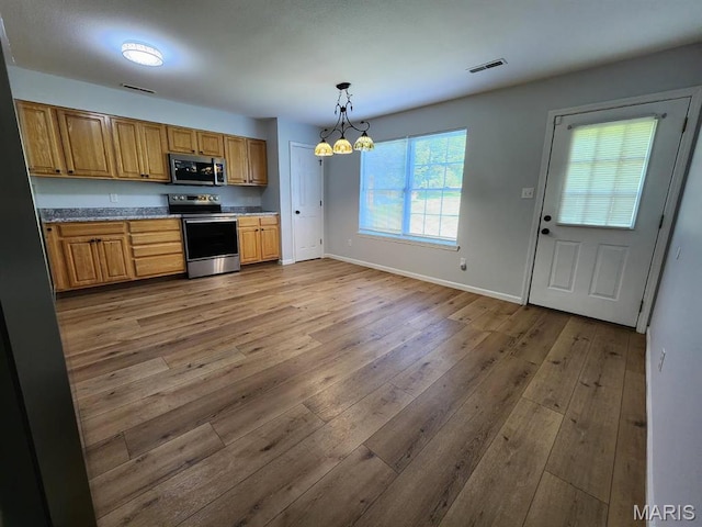 1604 Napoleon Dr, Bonne Terre, MO 63628 - kitchen featuring appliances with stainless steel finishes, hardwood / wood-style flooring, a chandelier, decorative light fixtures, and brown cabinetry