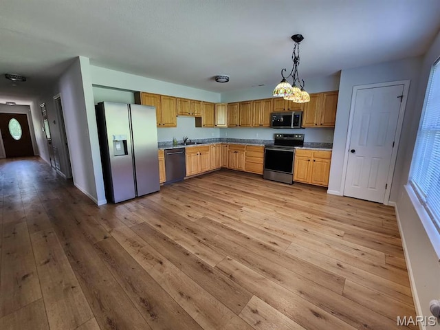 1604 Napoleon Dr, Bonne Terre, MO 63628 - kitchen featuring appliances with stainless steel finishes, light wood finished floors, decorative light fixtures, and light countertops