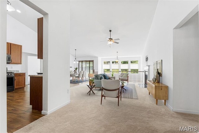 524 Pleasant Breeze Dr, Wentzville, MO 63385 - living area featuring high vaulted ceiling, a ceiling fan, carpet flooring, and wood finished floors