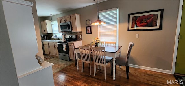 208 S Bast St, Jackson, MO 63755 - kitchen featuring appliances with stainless steel finishes, dark wood finished floors, tasteful backsplash, decorative light fixtures, and light countertops