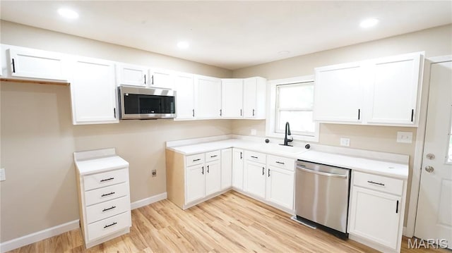 850 Cambridge Dr, Sikeston, MO 63801 - kitchen with appliances with stainless steel finishes, white cabinetry, light wood-type flooring, light countertops, and recessed lighting