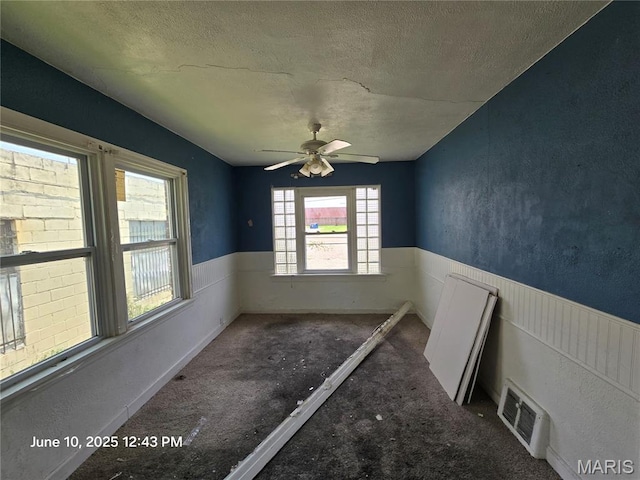 6203 Dardanella Ave, Normandy, MO 63121 - carpeted empty room with a textured ceiling, wainscoting, and ceiling fan