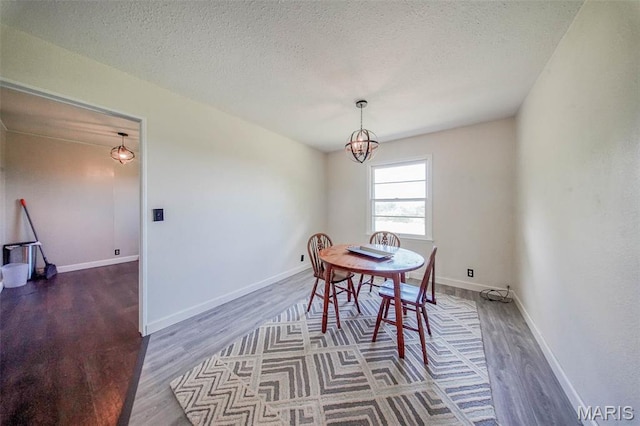12575 State Route F, Rolla, MO 65401 - dining area featuring wood finished floors, a textured ceiling, and a chandelier