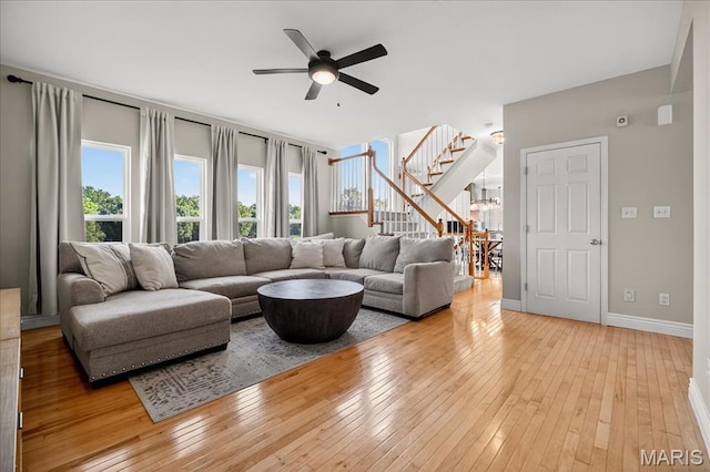 612 Thornridge Dr, Ofallon, MO 63368 - living room with a ceiling fan, stairway, light wood finished floors, and a chandelier
