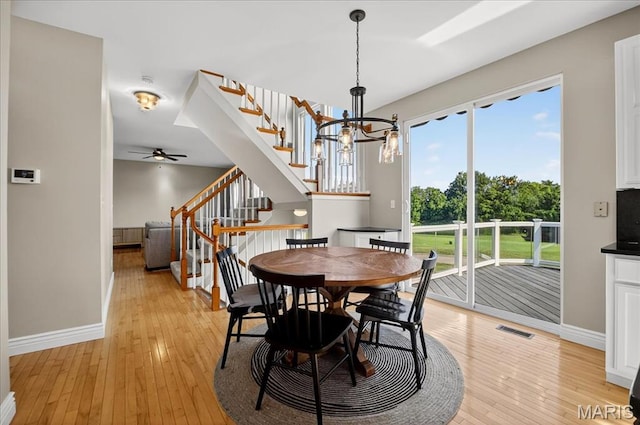 612 Thornridge Dr, Ofallon, MO 63368 - dining room featuring light wood finished floors, a chandelier, ceiling fan, and stairs